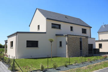 Maison contemporaine à étage avec toit en double pente, façade en enduit clair et parement pierre, menuiseries noires et jardin paysager