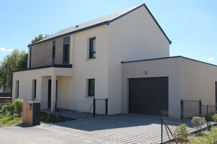 Maison contemporaine à toit plat et à double pente avec garage intégré et façade en enduit clair et parement en pierres